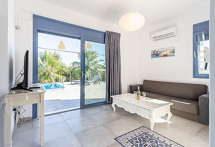 Open-plan living room with sofa, dining area, kitchen, A/C, WiFi internet, satellite TV, and terrace access . - Villa Seashell . (Fotogalerie) }}