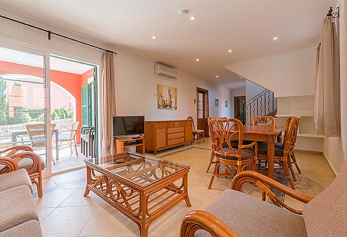 Open-plan living room with dining area, A/C, WiFi Internet, Satellite TV, DVD player, and terrace access  . - Villa Cala Galdana 7 . (Galleria fotografica) }}