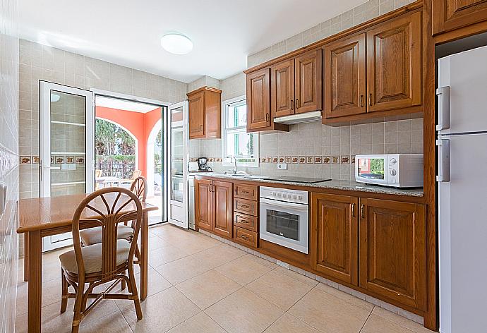 Equipped kitchen with dining area and terrace access . - Villa Cala Galdana 7 . (Fotogalerie) }}