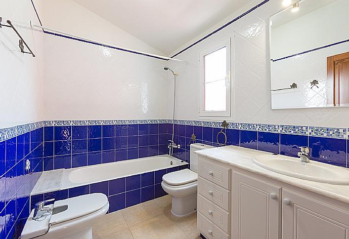 En suite bathroom with bath and overhead shower . - Villa Cala Galdana 7 . (Fotogalerie) }}