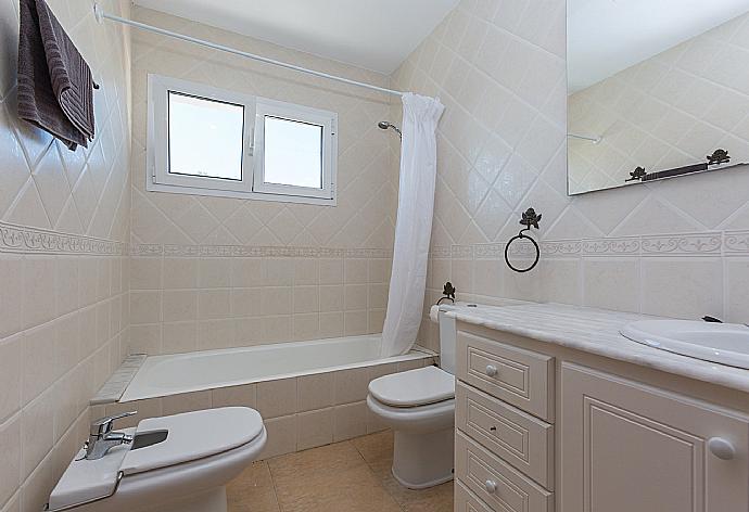 En suite bathroom with bath and overhead shower . - Villa Cala Galdana 8 . (Галерея фотографий) }}