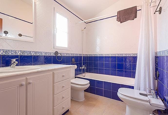 Family bathroom with bath and overhead shower . - Villa Cala Galdana 8 . (Fotogalerie) }}