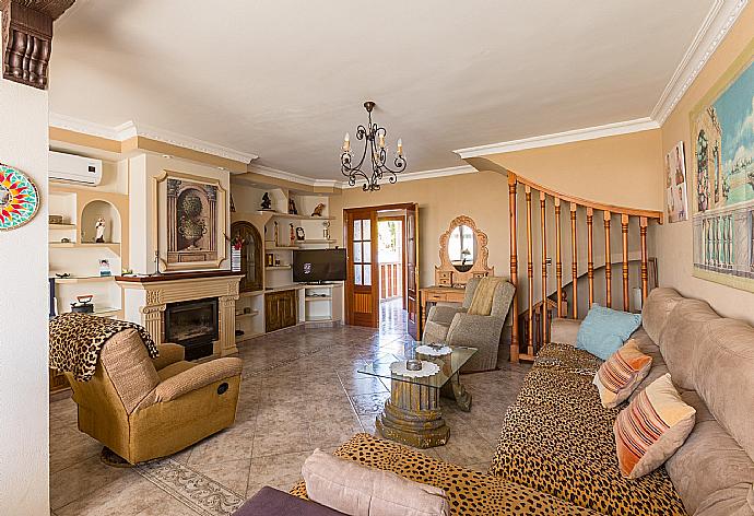 Open-plan living room with ornamental fireplace, TV and dining area . - Julio Romero . (Fotogalerie) }}