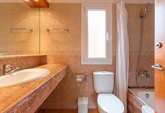En suite bathroom with bath and overhead shower . - Villa Geranio . (Fotogalerie) }}