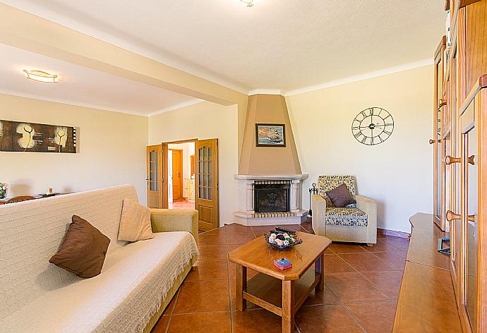 Living room with sofas, dining area, ornamental fireplace, WiFi internet, satellite TV, and DVD player . - Villa Amendoeira . (Photo Gallery) }}