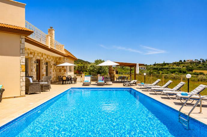 Sunny private pool area with a spacious terrace, sun loungers, and beautiful countryside views. . - Villa Christel . (Photo Gallery) }}