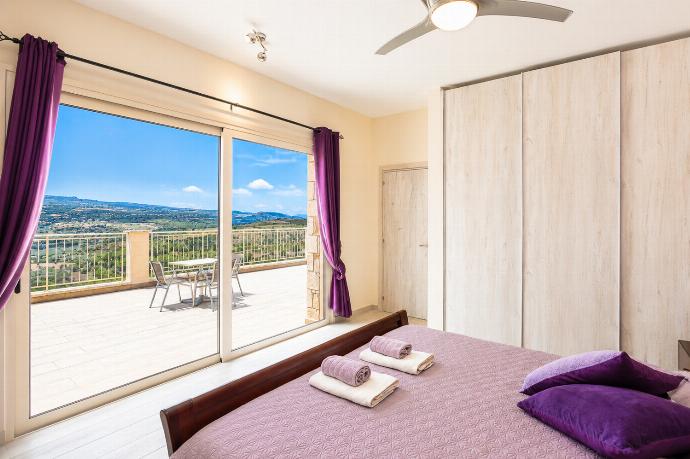 Bright bedroom with purple accents, spacious wardrobes, and a private terrace with countryside views. . - Villa Christel . (Photo Gallery) }}