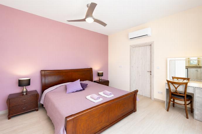Bright double bedroom with soft purple tones, wooden furniture, and a modern dressing area. . - Villa Christel . (Photo Gallery) }}