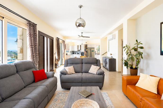 Bright open-plan living area with comfortable sofas, modern kitchen, and lovely pool terrace access. . - Villa Christel . (Photo Gallery) }}