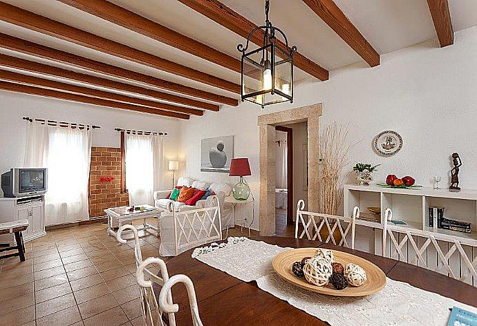 Open-plan living room with sofas, dining area, A/C, WiFi internet, satellite TV, DVD player, and terrace access . - Can Llobera . (Galería de imágenes) }}