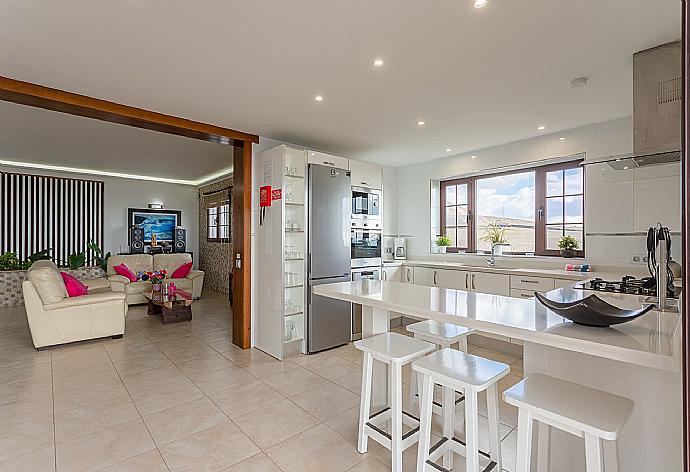 Open-plan living room with sofas, dining area, kitchen, ornamental fireplace, WiFi internet, satellite TV, DVD player, and pool terrace access . - Villa Santana . (Galería de imágenes) }}