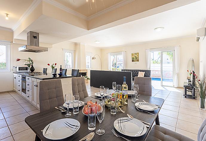 Open-plan living room with sofas, dining area, kitchen, ornamental fireplace, A/C, WiFi internet, and satellite TV . - Villa Petra . (Galleria fotografica) }}