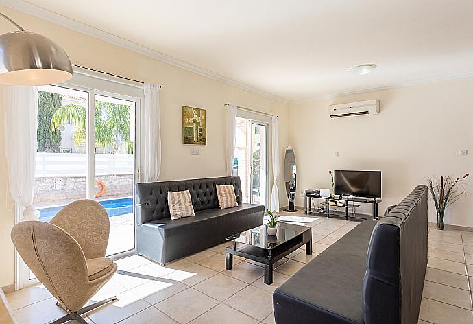 Open-plan living room with sofas, dining area, kitchen, ornamental fireplace, A/C, WiFi internet, and satellite TV . - Villa Petra . (Galería de imágenes) }}