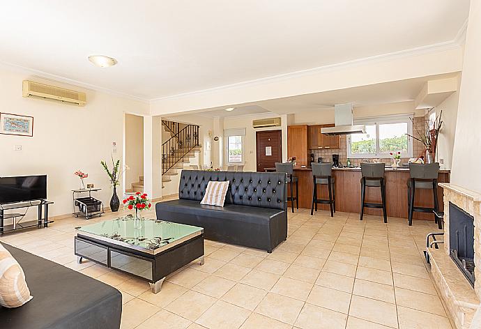 Open-plan living room with sofa, dining area, kitchen, ornamental fireplace, A/C, WiFi internet, and satellite TV . - Villa Chryso . (Galerie de photos) }}