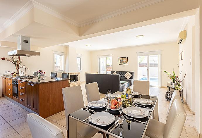 Open-plan living room with sofa, dining area, kitchen, ornamental fireplace, A/C, WiFi internet, and satellite TV . - Villa Chryso . (Galleria fotografica) }}