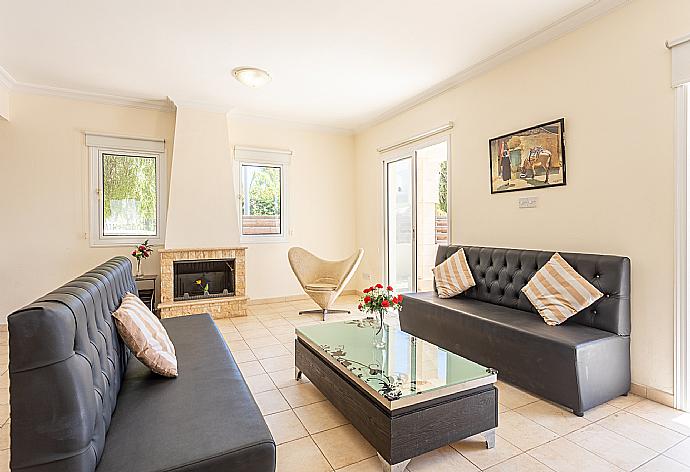 Open-plan living room with sofa, dining area, kitchen, ornamental fireplace, A/C, WiFi internet, and satellite TV . - Villa Chryso . (Fotogalerie) }}