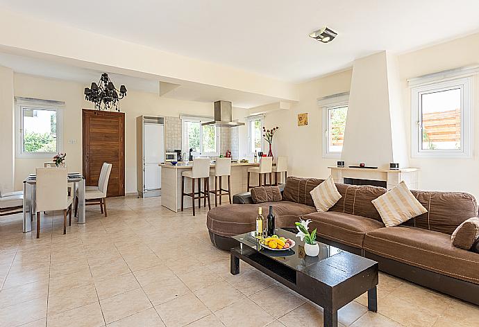 Open-plan living room with sofa, dining area, kitchen, ornamental fireplace, A/C, WiFi internet, and satellite TV . - Villa Nikol . (Fotogalerie) }}