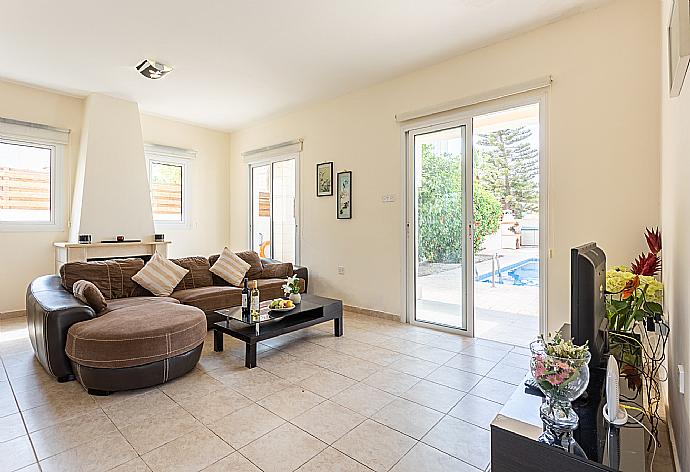 Open-plan living room with sofa, dining area, kitchen, ornamental fireplace, A/C, WiFi internet, and satellite TV . - Villa Nikol . (Galerie de photos) }}