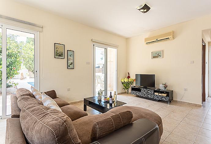 Open-plan living room with sofa, dining area, kitchen, ornamental fireplace, A/C, WiFi internet, and satellite TV . - Villa Nikol . (Fotogalerie) }}