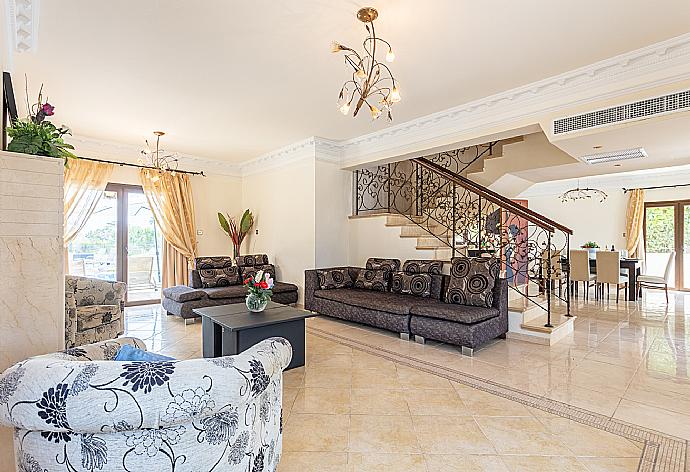 Open-plan living room with sofas, dining area, kitchen, ornamental fireplace, A/C, WiFi internet, and satellite TV . - Villa  Elysia . (Photo Gallery) }}