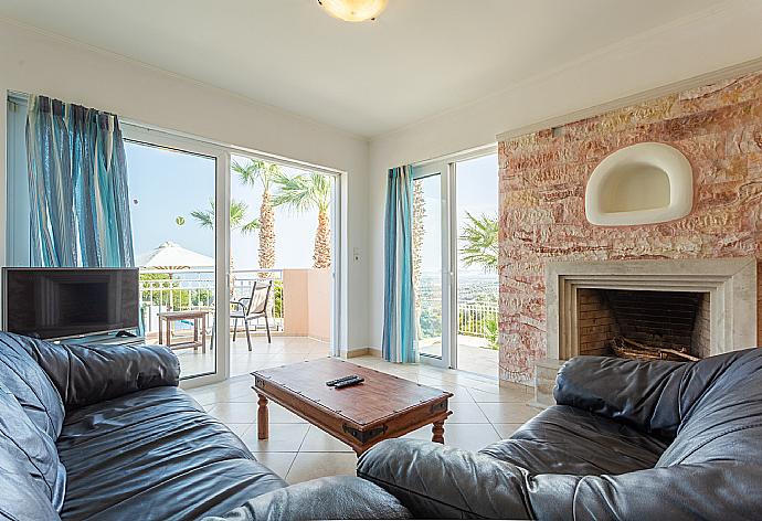 Open-plan living room with sofas, dining area, kitchen, ornamental fireplace, A/C, WiFi internet, satellite TV, and terrace access . - Villa Astro . (Fotogalerie) }}