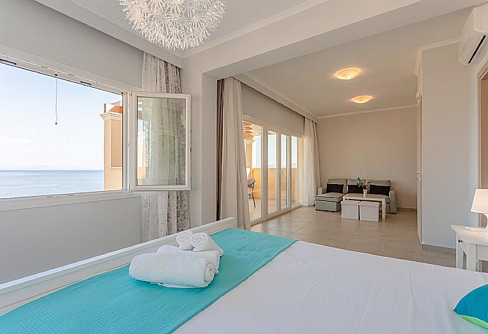 Double bedroom with en suite bathroom, A/C, living area, walk-in wardrobe, and balcony access . - Villa Aurora . (Photo Gallery) }}