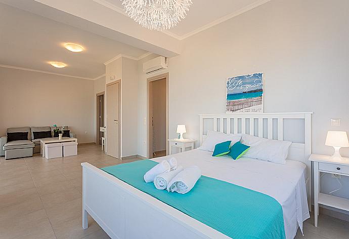 Double bedroom with en suite bathroom, A/C, living area, walk-in wardrobe, and balcony access . - Villa Aurora . (Photo Gallery) }}