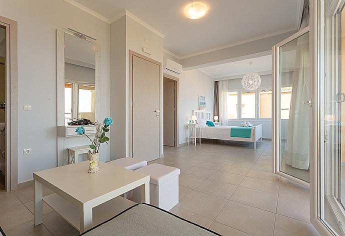 Double bedroom with en suite bathroom, A/C, living area, walk-in wardrobe, and balcony access . - Villa Aurora . (Photo Gallery) }}