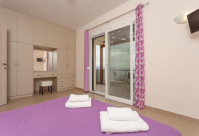 Double bedroom on second floor with en suite bathroom, A/C, TV, and balcony access . - Villa Alya . (Galerie de photos) }}