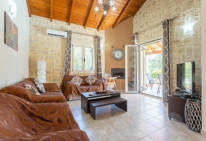 Open-plan living room with sofas, dining area, kitchen, ornamental fireplace, A/C, WiFi internet, satellite TV, DVD player, and terrace access . - Villa Popi . (Fotogalerie) }}