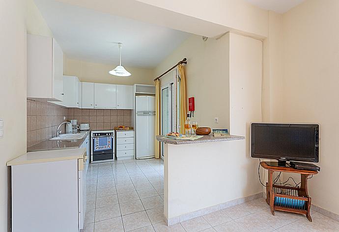 Open-plan living room on ground floor with dining area, equipped kitchen, A/C, WiFi Internet, Satellite TV, DVD player, and terrace access . - Skala Villa Blue . (Galería de imágenes) }}