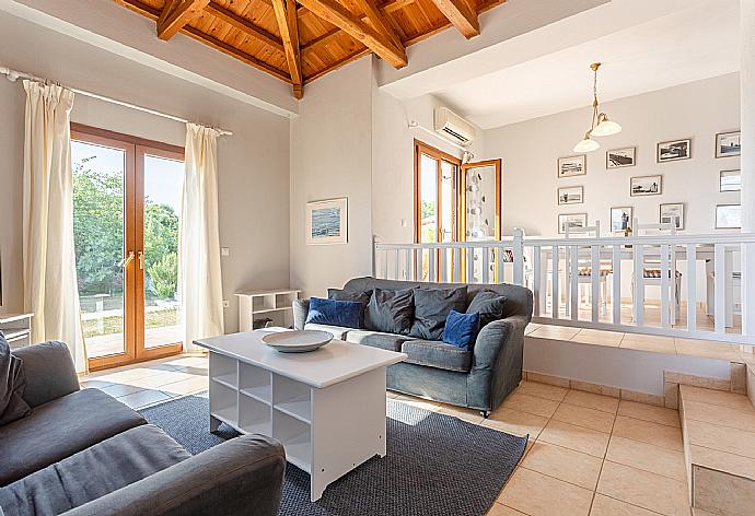 Open-plan living room with sofas, dining area, kitchen, A/C, WiFi internet, satellite TV, DVD player, and pool terrace access . - Villa Glafki . (Fotogalerie) }}