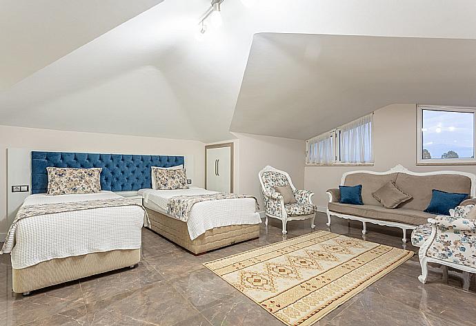 Twin bedroom with en suite bathroom, living area, A/C, and TV . - Villa Ozcelik . (Photo Gallery) }}