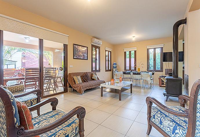 Open-plan living room with sofas, dining area, kitchen, A/C, WiFi internet, satellite TV, DVD player, fireplace, and terrace access  . - Villa Kinousa 2 . (Fotogalerie) }}