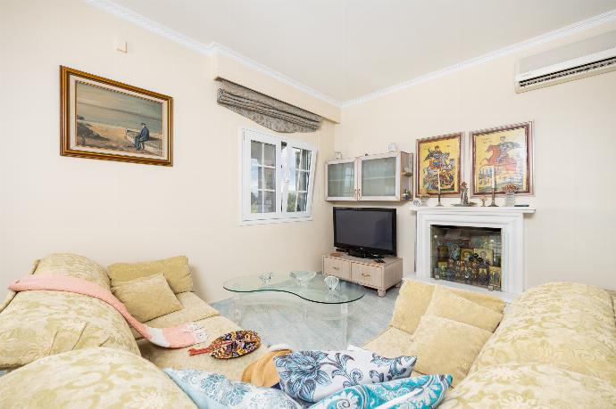 Open-plan living room with sofa, dining area, kitchen, ornamental fireplace, A/C, WiFi internet, and satellite TV . - Villa Psaropouli . (Photo Gallery) }}