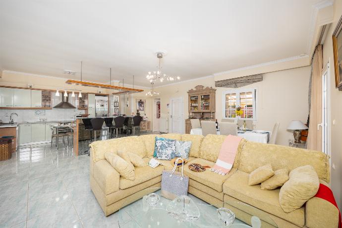 Open-plan living room with sofa, dining area, kitchen, ornamental fireplace, A/C, WiFi internet, and satellite TV . - Villa Psaropouli . (Photo Gallery) }}