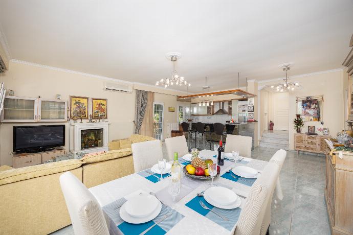 Open-plan living room with sofa, dining area, kitchen, ornamental fireplace, A/C, WiFi internet, and satellite TV . - Villa Psaropouli . (Photo Gallery) }}