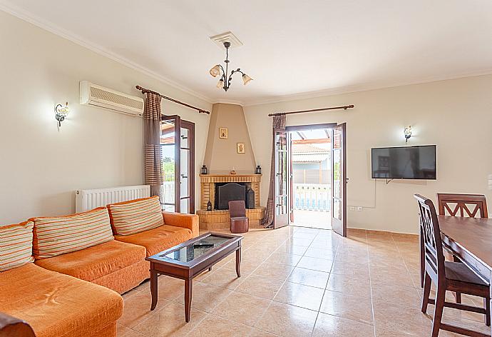 Open-plan living room with sofas, dining area, kitchen, ornamental fireplace, A/C, WiFi Internet, satellite TV, and terrace access . - Villa Bora . (Photo Gallery) }}
