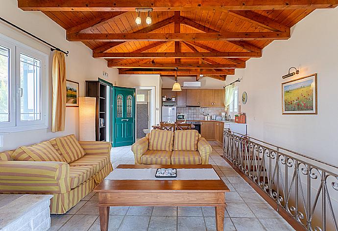 Open-plan living room with sofas, dining area, kitchen, ornamental fireplace, A/C, WiFi internet, satellite TV, and balcony access with panoramic sea views . - Villa Votsalo . (Galleria fotografica) }}