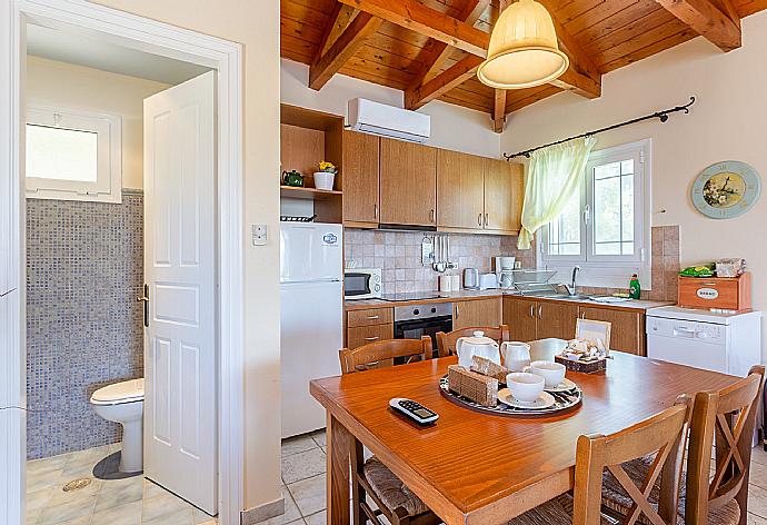 Dining area and equipped kitchen . - Villa Votsalo . (Photo Gallery) }}