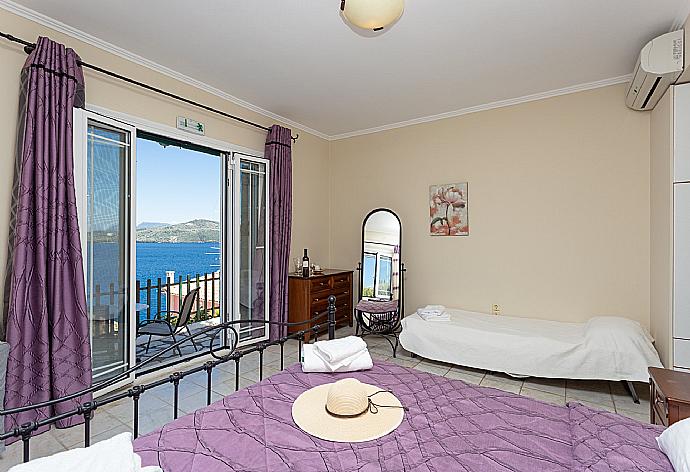 Double bedroom with extra single bed, en suite bathroom, AC, and terrace access with panoramic sea views . - Villa Votsalo . (Galleria fotografica) }}