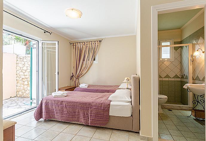 Twin bedroom with en suite bathroom, A/C, and terrace access . - Villa Votsalo . (Galerie de photos) }}