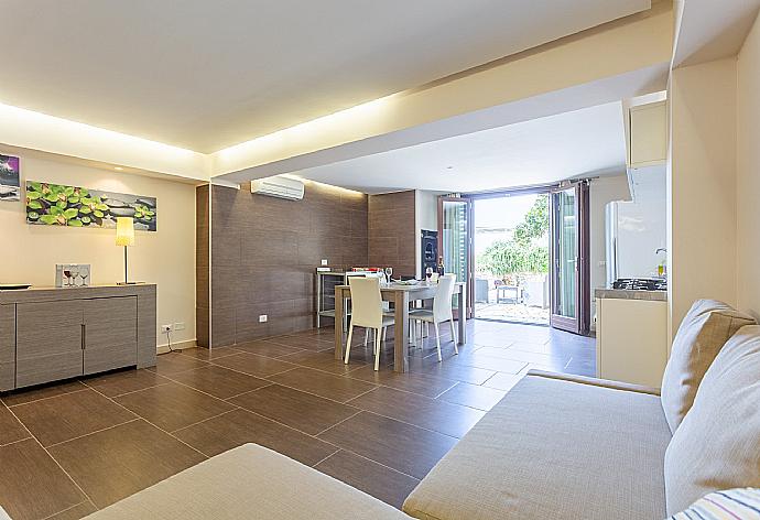 Open-plan living room of self-contained unit (accessible internally and externally) with sofa, dining area, kitchen, double bed, en suite bathroom, A/C, WiFi internet, and terrace access . - Villa Palazzola . (Galería de imágenes) }}