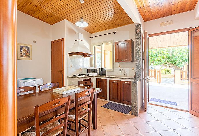 Open-plan living room with sofa, dining area, equipped kitchen, A/C, WiFi internet, satellite TV, and terrace access . - Villa Dune . (Galerie de photos) }}