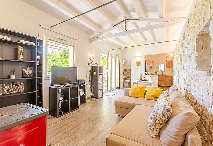 Open-plan living room in annex with sofas, dining area, kitchen, ornamental fireplace, A/C, WiFi internet, satellite TV, and terrace access . - Villa Aziz . (Fotogalerie) }}