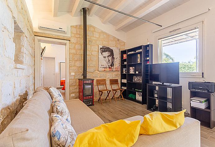 Open-plan living room in annex with sofas, dining area, kitchen, ornamental fireplace, A/C, WiFi internet, satellite TV, and terrace access . - Villa Aziz . (Fotogalerie) }}