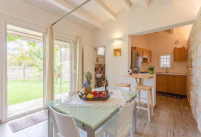 Open-plan living room in annex with sofas, dining area, kitchen, ornamental fireplace, A/C, WiFi internet, satellite TV, and terrace access . - Villa Aziz . (Galería de imágenes) }}