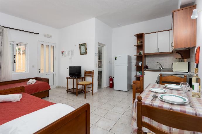 Open-plan living room with dining area, kitchen, two single beds, A/C, WiFi internet, and satellite TV . - Fotini . (Galleria fotografica) }}