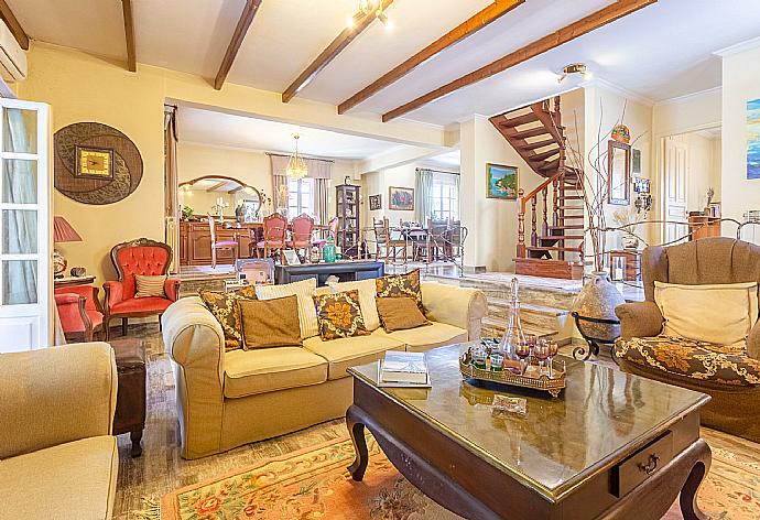 Open-plan living room with sofas, dining areas, kitchen, ornamental fireplace, WiFi internet, satellite TV, DVD player, A/C, and pool terrace access . - Villa Durrell . (Galería de imágenes) }}