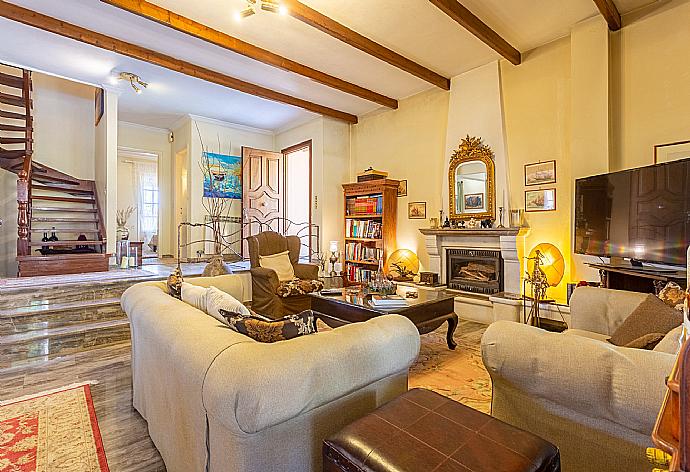 Open-plan living room with sofas, dining areas, kitchen, ornamental fireplace, WiFi internet, satellite TV, DVD player, A/C, and pool terrace access . - Villa Durrell . (Fotogalerie) }}